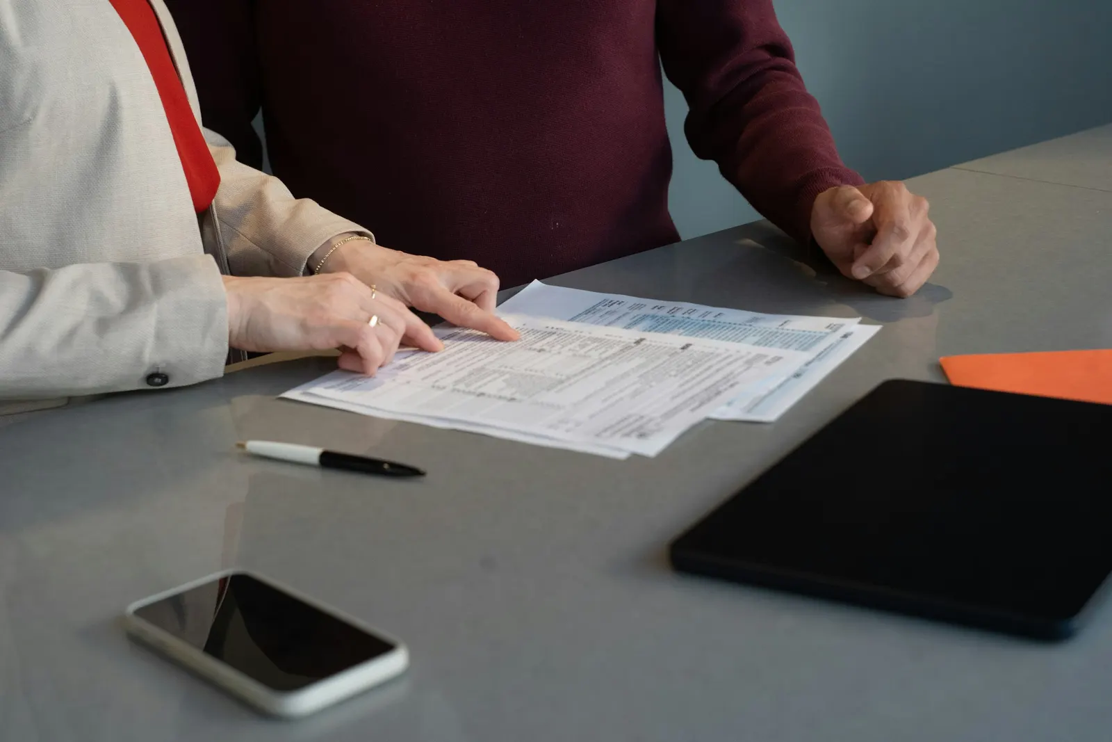 Two people reviewing a paper form at a table.