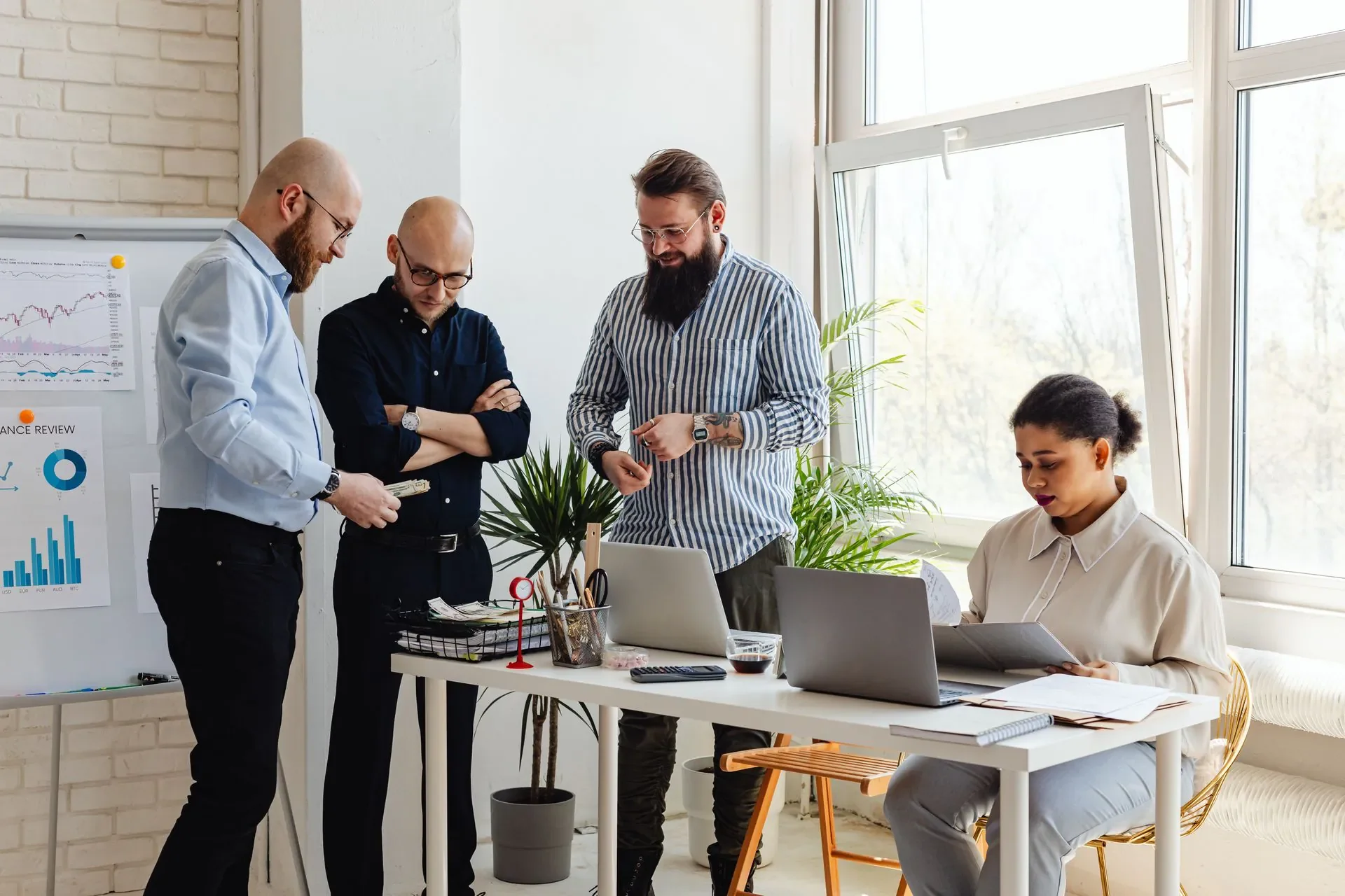 Colleagues work together at a table in a bright office.
